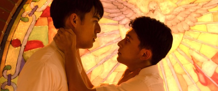 Jia-han (left) and his underclassman (right), backlit by a stained glass window. The underclassman has his arms around Jia-han, while Jia-han's hand is on the other's throat.