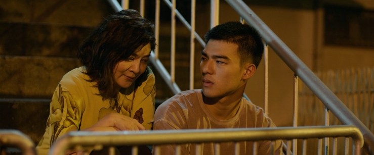 Jia-han (right) sitting beside his mother (left) on the emergency stairs leading up to his house.